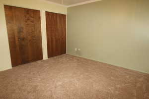 Primary bedroom featuring ornamental molding, and ceiling fan