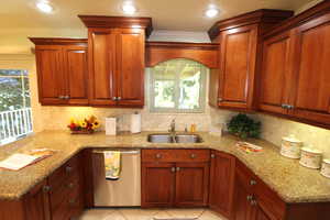 Kitchen with light tile patterned floors, sink, crown molding, kitchen bar, and plenty of cabinets