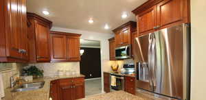 Kitchen with light tile patterned floors, sink, crown molding, kitchen bar, and plenty of cabinets