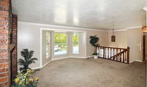 Spacious living room featuring a brick fireplace, bay window, and crown molding