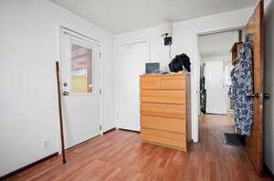 Bedroom featuring multiple windows,  wood-type flooring and private walkout to large back porch