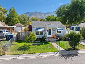 Bungalow-style house with a mountain view, fruit trees, and a front lawn