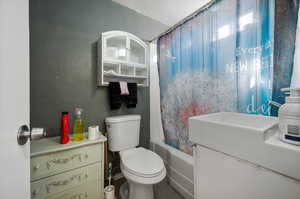 Full bathroom with vanity, toilet, and shower / tub combo with curtain