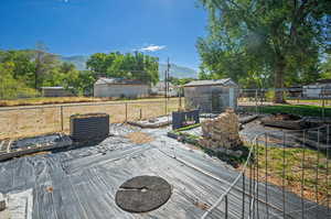 Wooden terrace featuring a raised garden, fenced vegetable gardens, and a mountain view