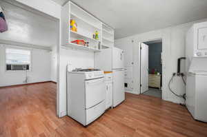 Kitchen featuring cooling unit, white appliances, light hardwood / wood-style floors, and a textured ceiling