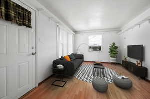 Living room featuring cooling unit and hardwood / wood-style flooring, natural light