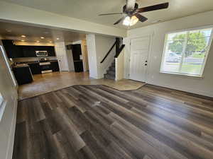 Entrance foyer with ceiling fan, sink, dark wood-type flooring, and a textured ceiling