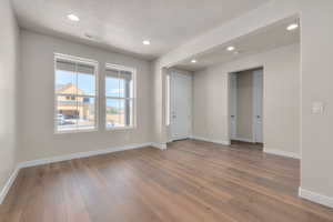 Spare room featuring a textured ceiling and hardwood / wood-style flooring