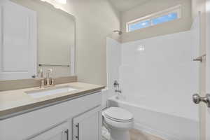 Full bathroom with vanity, toilet, and  shower combination