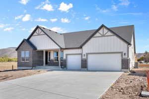 View of front of property with covered porch, a garage, a mountain view, and central AC unit