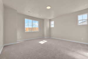 Spare room featuring carpet and a textured ceiling