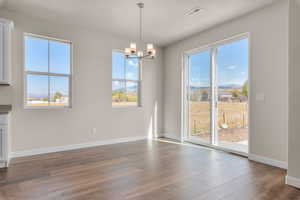 Unfurnished dining area featuring hardwood / wood-style floors, a textured ceiling, and plenty of natural light