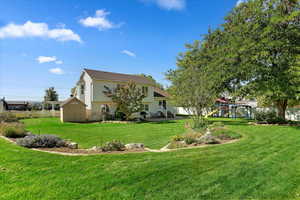 Exterior space featuring a playground, a yard, and a storage unit