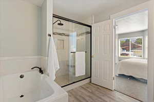 Bathroom with wood-type flooring and separate shower and tub