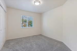 Unfurnished bedroom featuring light colored carpet and a closet