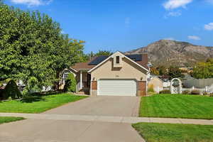 View of front of house with a garage, a mountain view, and a front yard