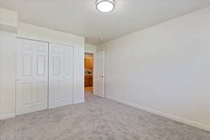 Unfurnished bedroom featuring light colored carpet and a closet