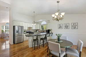 Dining area featuring light wood-type flooring, vaulted ceiling, plenty of natural light, and sink