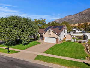 View of front of property with a garage, a mountain view, and a front yard