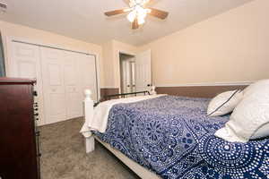 Carpeted bedroom featuring a closet and ceiling fan