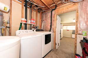 Washroom with washing machine and clothes dryer and light carpet