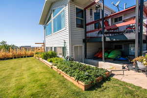 View of property exterior featuring a wooden deck, a yard, and a patio area