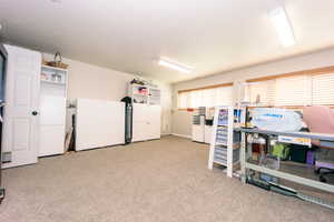 Interior space featuring light colored carpet and white refrigerator