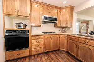 Kitchen with appliances with stainless steel finishes, sink, and dark hardwood / wood-style floors