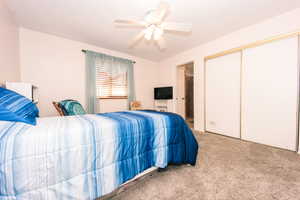 Bedroom with carpet, ceiling fan, and a closet