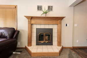 Details featuring a tile fireplace and hardwood / wood-style flooring