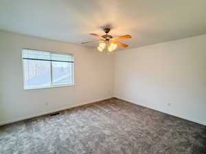 Carpeted empty room with ceiling fan