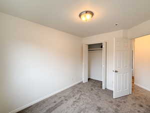 Unfurnished bedroom with carpet and a closet