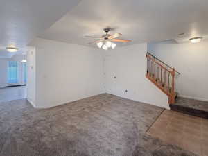 Unfurnished living room with carpet floors and ceiling fan