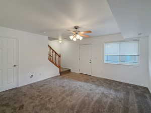 Carpeted empty room featuring ceiling fan