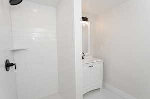 Bathroom featuring vanity and a tile shower