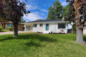 Ranch-style house featuring a front yard and a garage