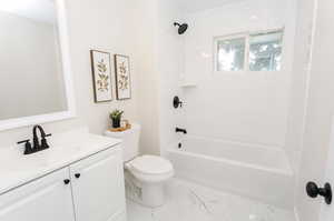 Full bathroom with tiled shower / bath, vanity, and toilet