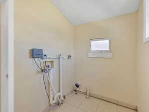 Washroom featuring hookup for an electric dryer, hookup for a washing machine, and light tile patterned floors