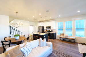 Living room featuring an inviting chandelier, sink, and dark hardwood / wood-style flooring