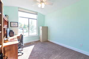 Office space with carpet floors, vaulted ceiling, and ceiling fan