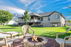 Exterior space with a lawn, a patio, a mountain view, and a fire pit