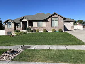 View of front of property with a garage and a front lawn