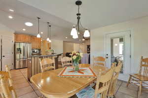 Dining room with light tile patterned flooring and a chandelier