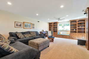 Carpeted living room featuring ceiling fan