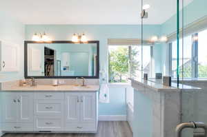 Bathroom featuring vanity, a bath, and hardwood / wood-style flooring