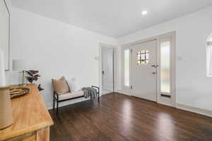 Entry with dark hardwood floors and stained-glass windows.