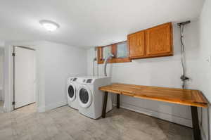 Washroom featuring cabinets and separate washer and dryer.