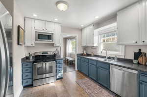 Stainless steel range,  microwave, and dishwasher in the kitchen with an abundance of natural light.