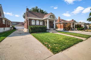 View of front of home featuring a front yard and a detached garage.