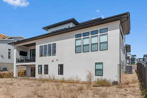 Rear view of house featuring a balcony and central air condition unit